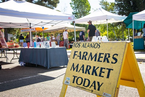 Farmers Market Sign Image with the market tents in the background