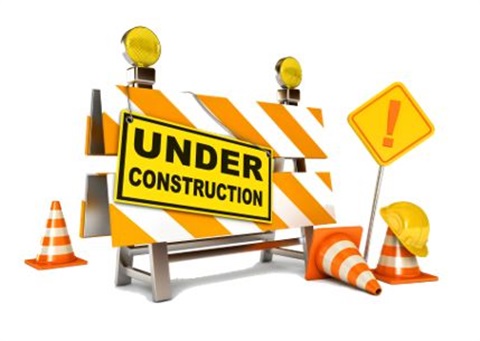 Image of traffic control and safety devices including orange cones, barricades with lights.