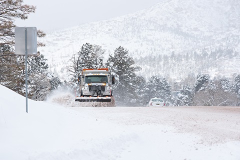 Snowy Road in Los Alamos being plowed by a snow vehicle