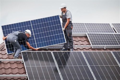 Two men on roof installing solar panels