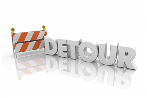 The word detour next to a traffic barrier