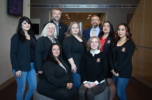 Portrait of the LAFD Administrative Staff sitting and standing, depicting top down and L to R: Joshua Sammons, Xavier Anderson, Danielle Bustos, Norma Valdez, Marisol Padilla, Ana Martinez, Samantha Gil, Nichol Gallegos, and Molly Fischer